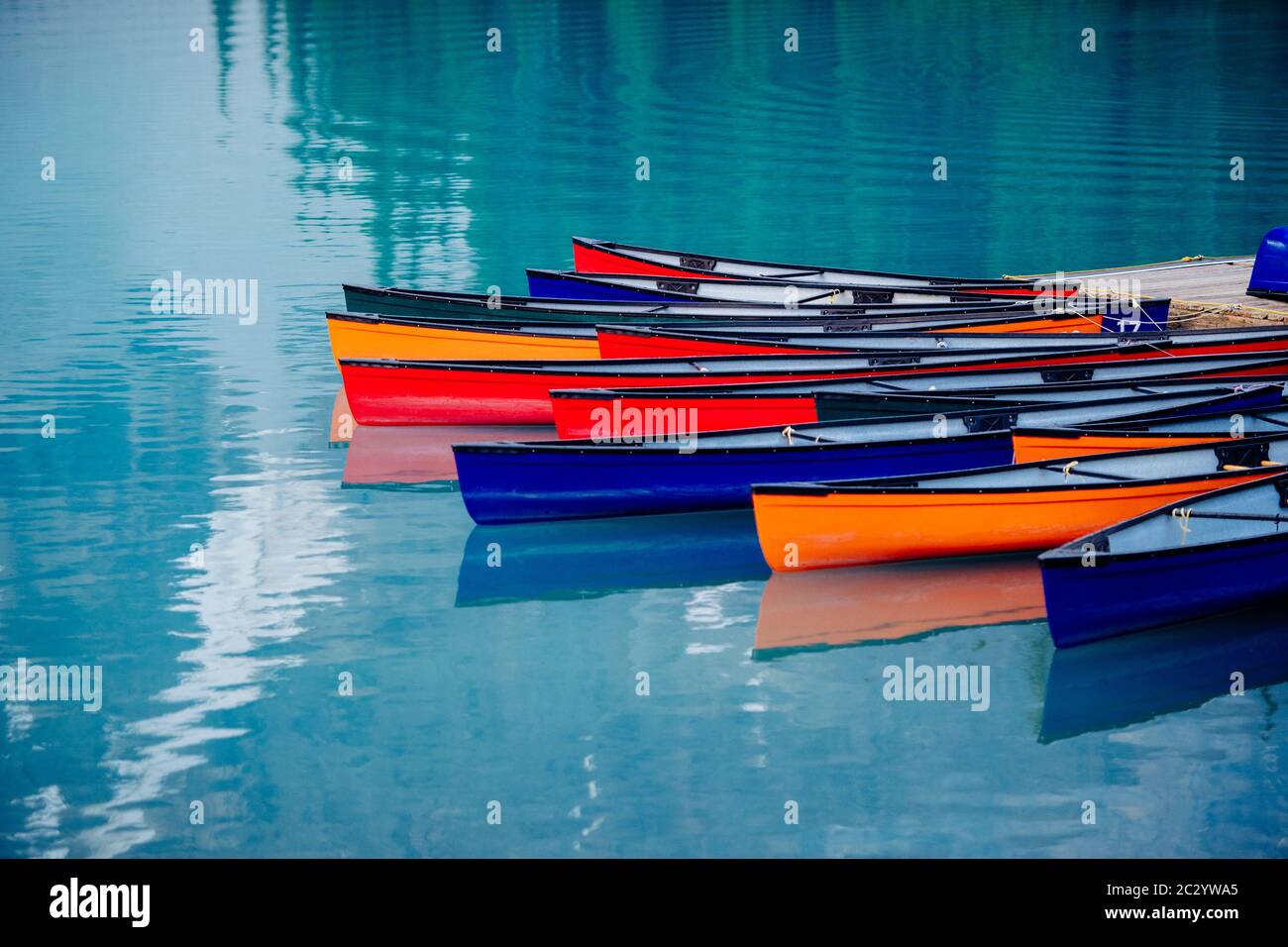 Barques colorées amarrées dans un lac calme, Banff, Alberta, Canada Banque D'Images
