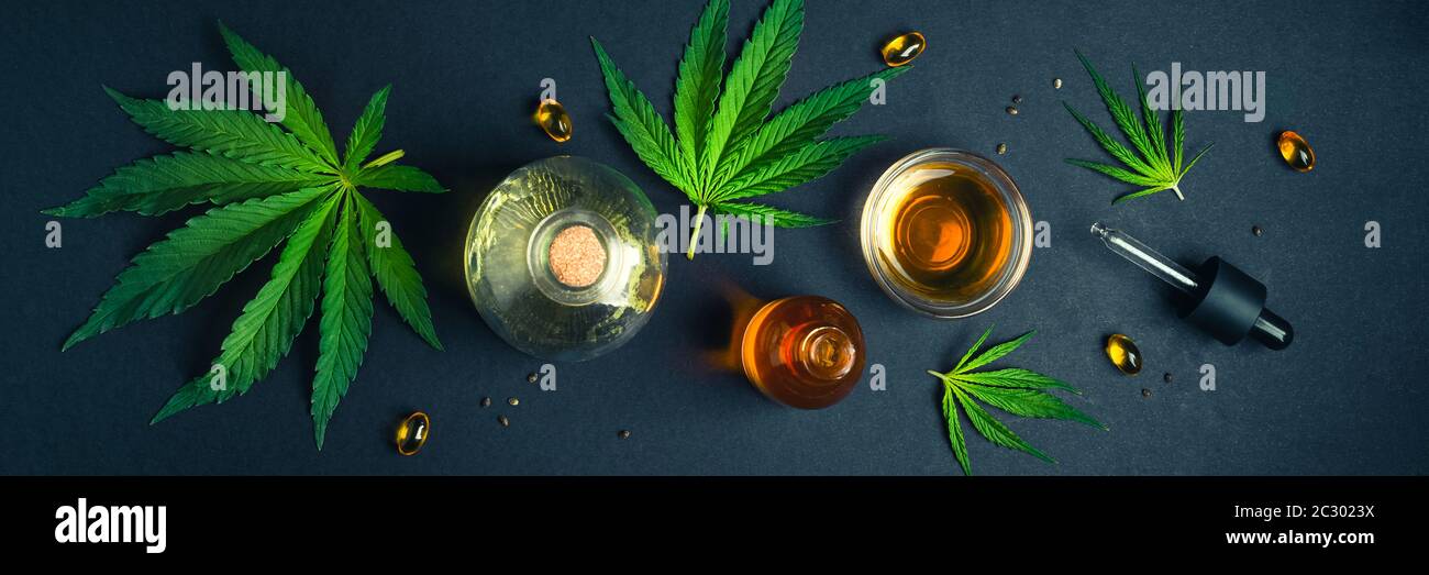 Huile de CBD médicale, teinture sur fond noir branché avec feuilles de cannabis Banque D'Images