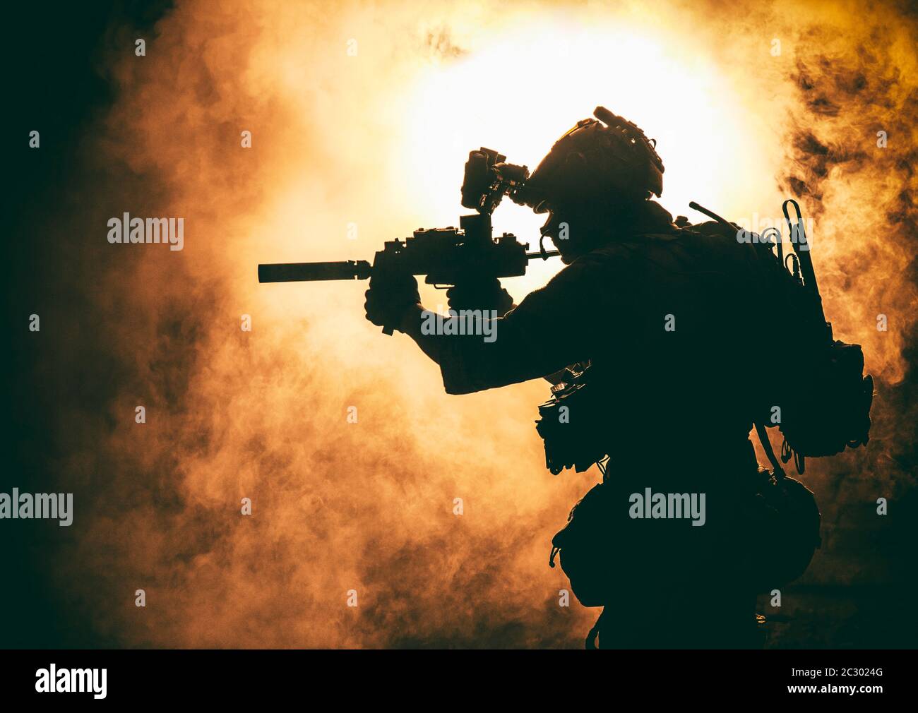 Silhouette de soldat d'infanterie moderne, combattant d'élite de l'armée en munitions tactiques et casque, debout avec une carabine de service d'assaut dans les mains sur backgroun Banque D'Images