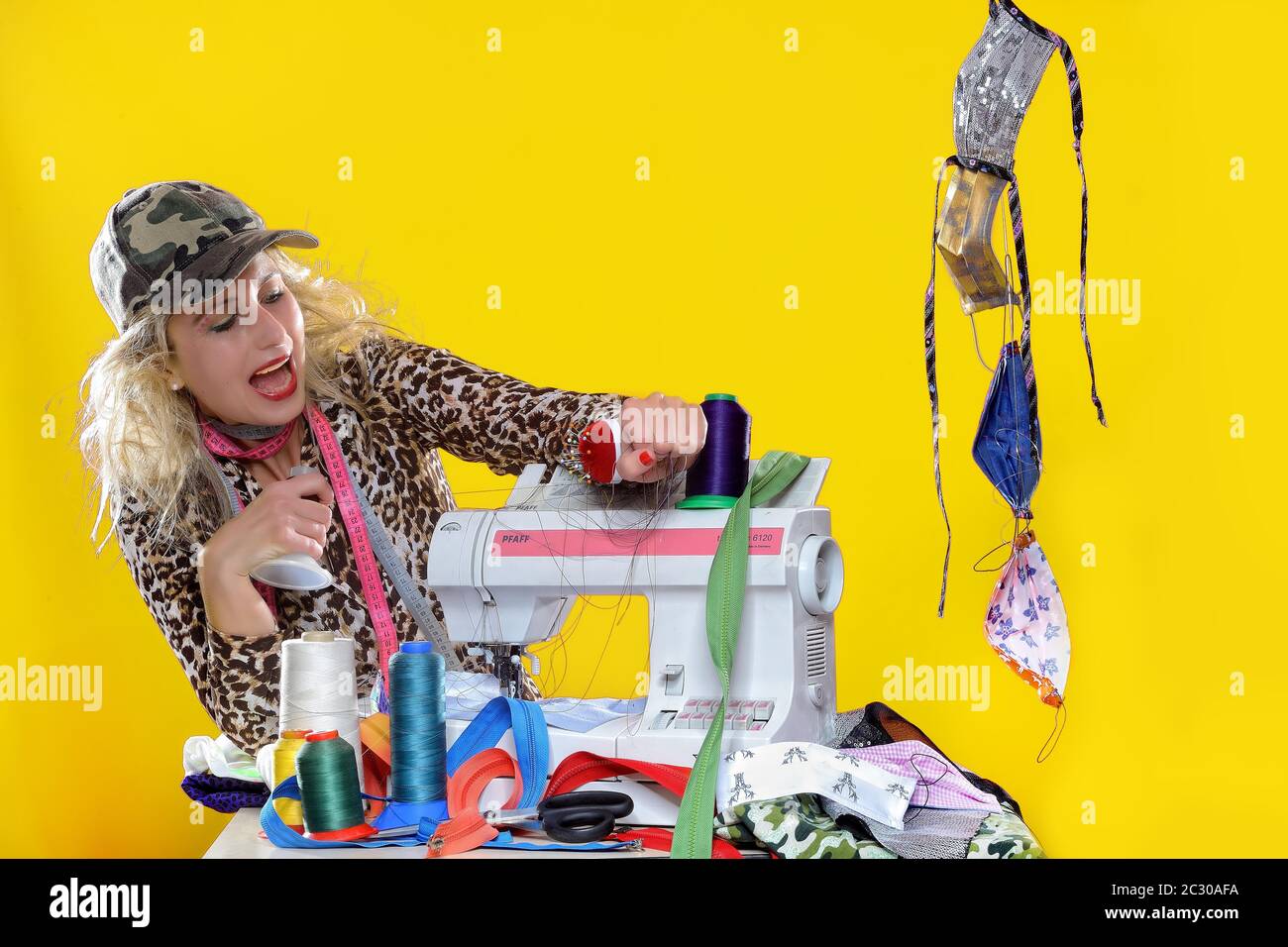 Jeune femme avec machine à coudre, masques de couture, Allemagne Banque D'Images