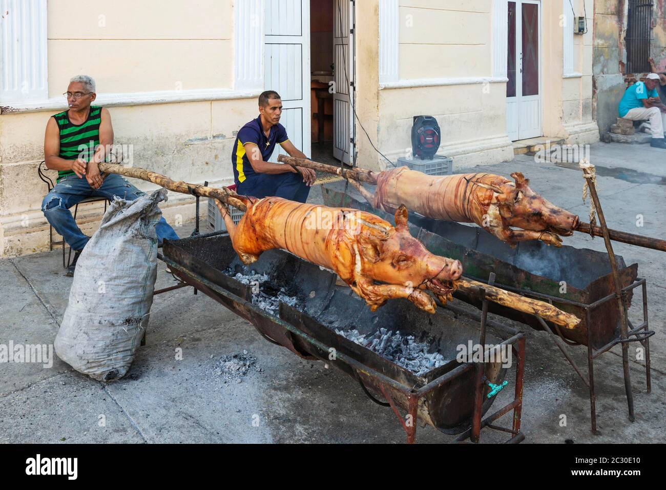 Rôtir des porcs dans une zone piétonne du centre-ville afin de vendre ultérieurement des portions de viande au public, Manzanillo, Cuba Banque D'Images