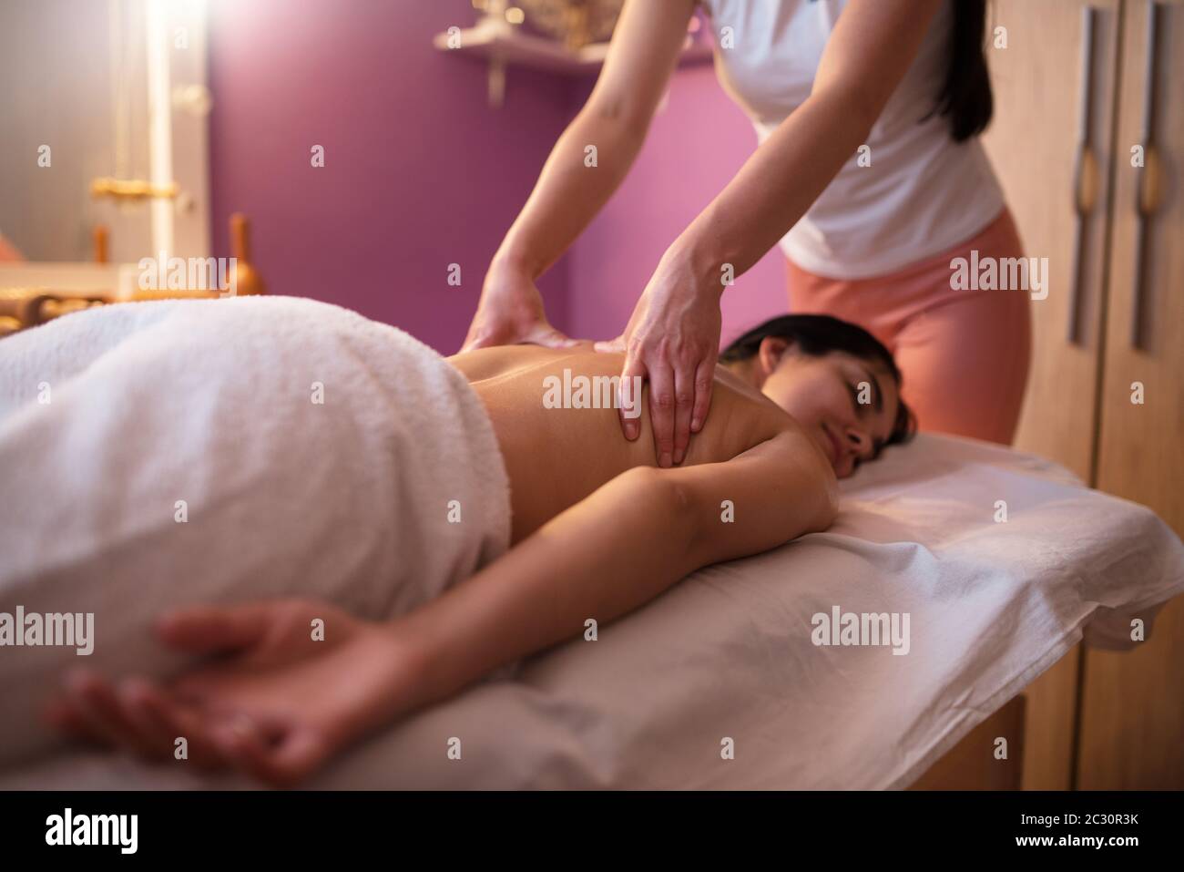 Jeune femme recevant un massage dans le salon de spa. Banque D'Images