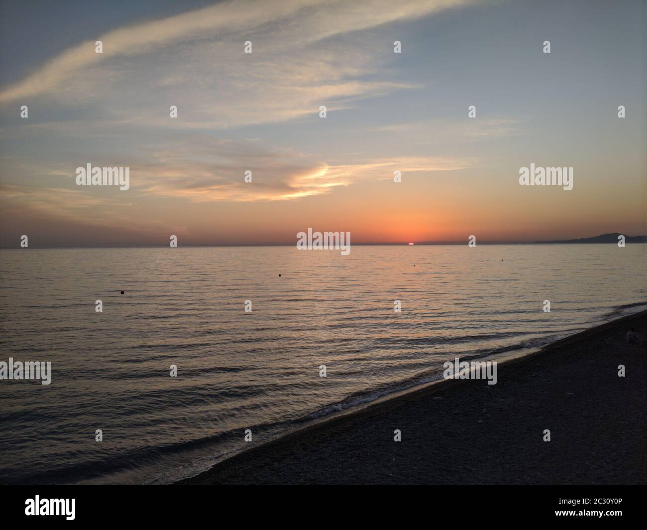 Paysage marin avec ciel bleu et orange et soleil doré. La mer Noire dans la région de Krasnodar. En premier plan-une plage de sable, silhouettes de gens, UM Banque D'Images
