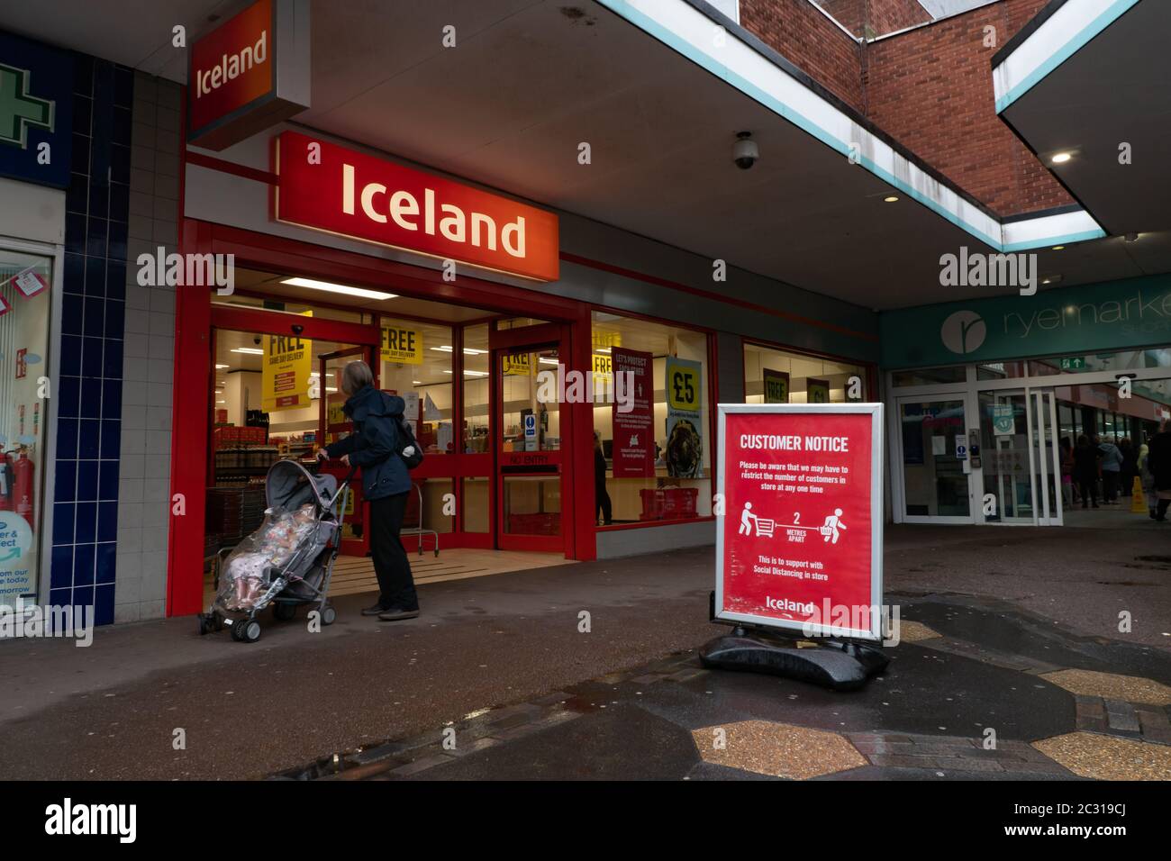 Panneau à l'extérieur de l'avant de l'atelier en Islande demandant aux clients de garder 2 m à l'écart. Stourbridge. West Midlands. ROYAUME-UNI Banque D'Images