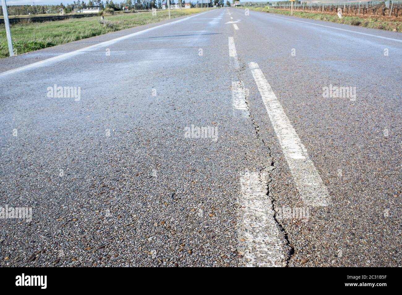 Nouvelle route avec l'asphalte fissuré à surface country way. L'exécution déficiente de concept de construction civile Banque D'Images