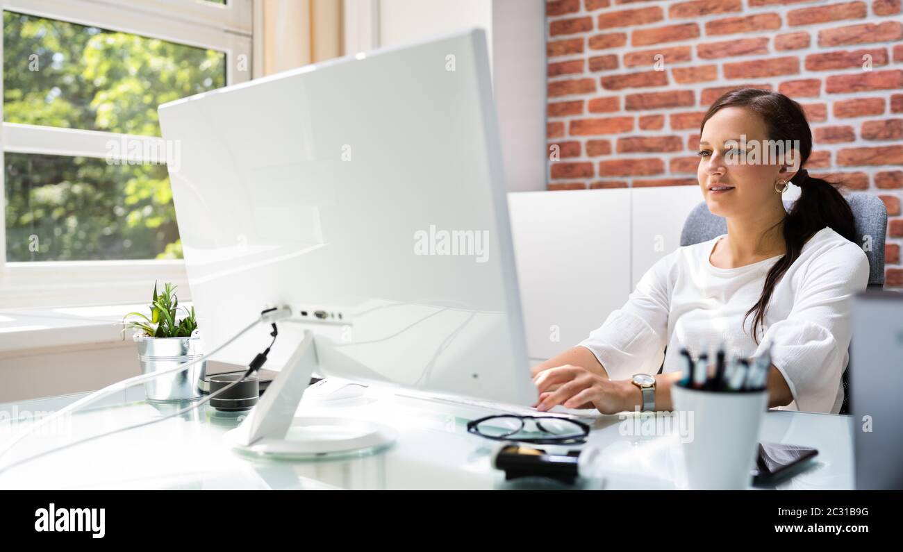 Bonne femme professionnelle employée utilisant l'ordinateur pour le travail Banque D'Images