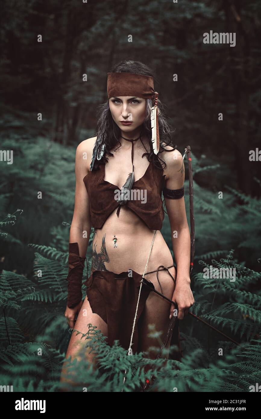 huntress dangereux posant avec l'arc dans la forêt Banque D'Images