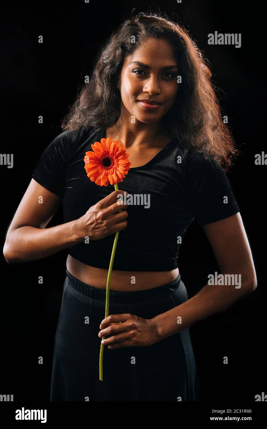 Femme tenant une fleur d'orange Banque D'Images