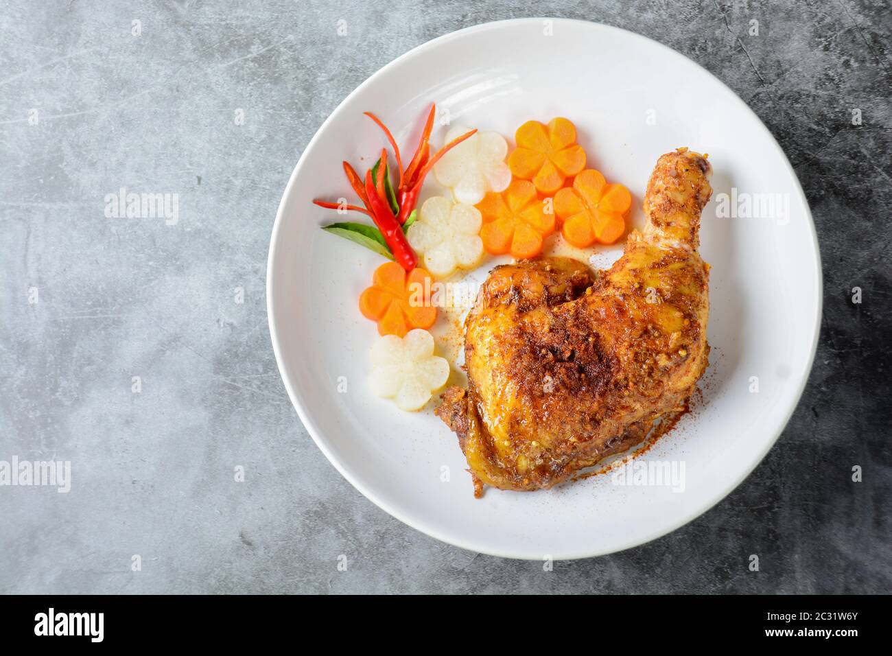 Poulet cuit chaud et épicé sur plaque blanche Banque D'Images