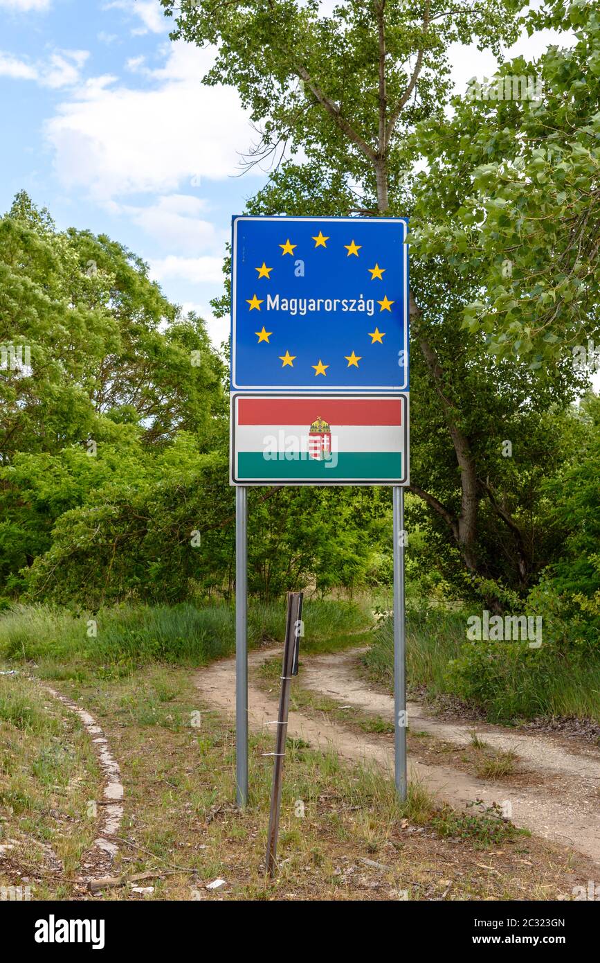 Un panneau de passage frontalier hongrois à côté d'une route de terre Banque D'Images