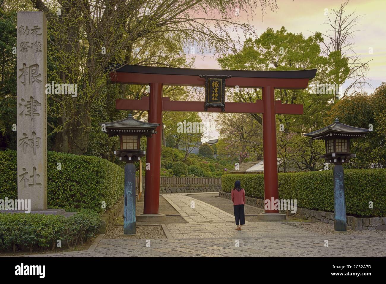 Femme debout à l'entrée du sanctuaire Shintoïste Nezu du XVIIIe siècle à Tokyo Banque D'Images