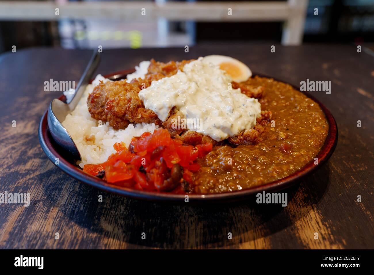 Vue rapprochée au poulet frit japonais au curry de style Nanban avec riz, œuf dur et légumes marinés rouges. Banque D'Images