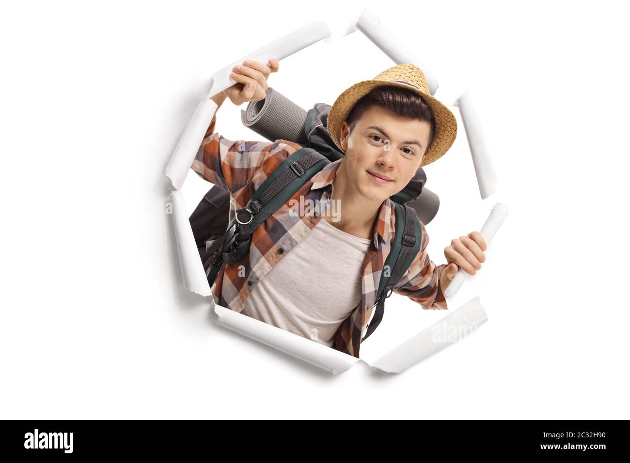 Jeune adolescent routard touriste peeking à travers un trou de papier isolé sur fond blanc Banque D'Images