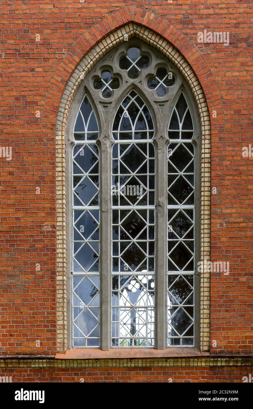 La vieille fenêtre dans le mur de brique rouge. Banque D'Images