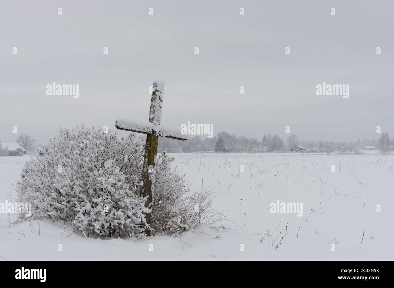 Old weathered wooden croix catholique sur une prairie enneigée Banque D'Images