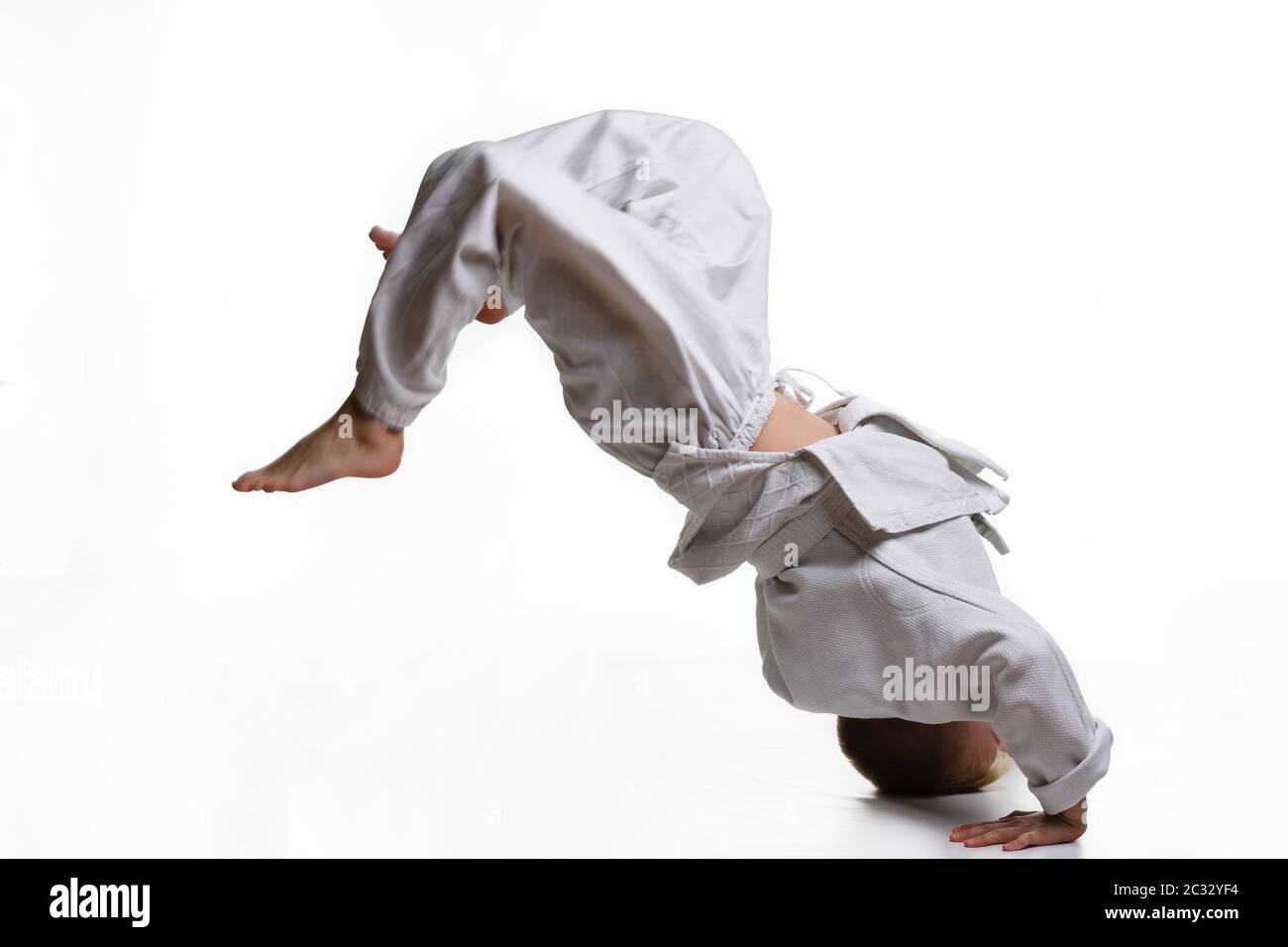 Judo garçon dans kimono blanc faisant somersault Banque D'Images