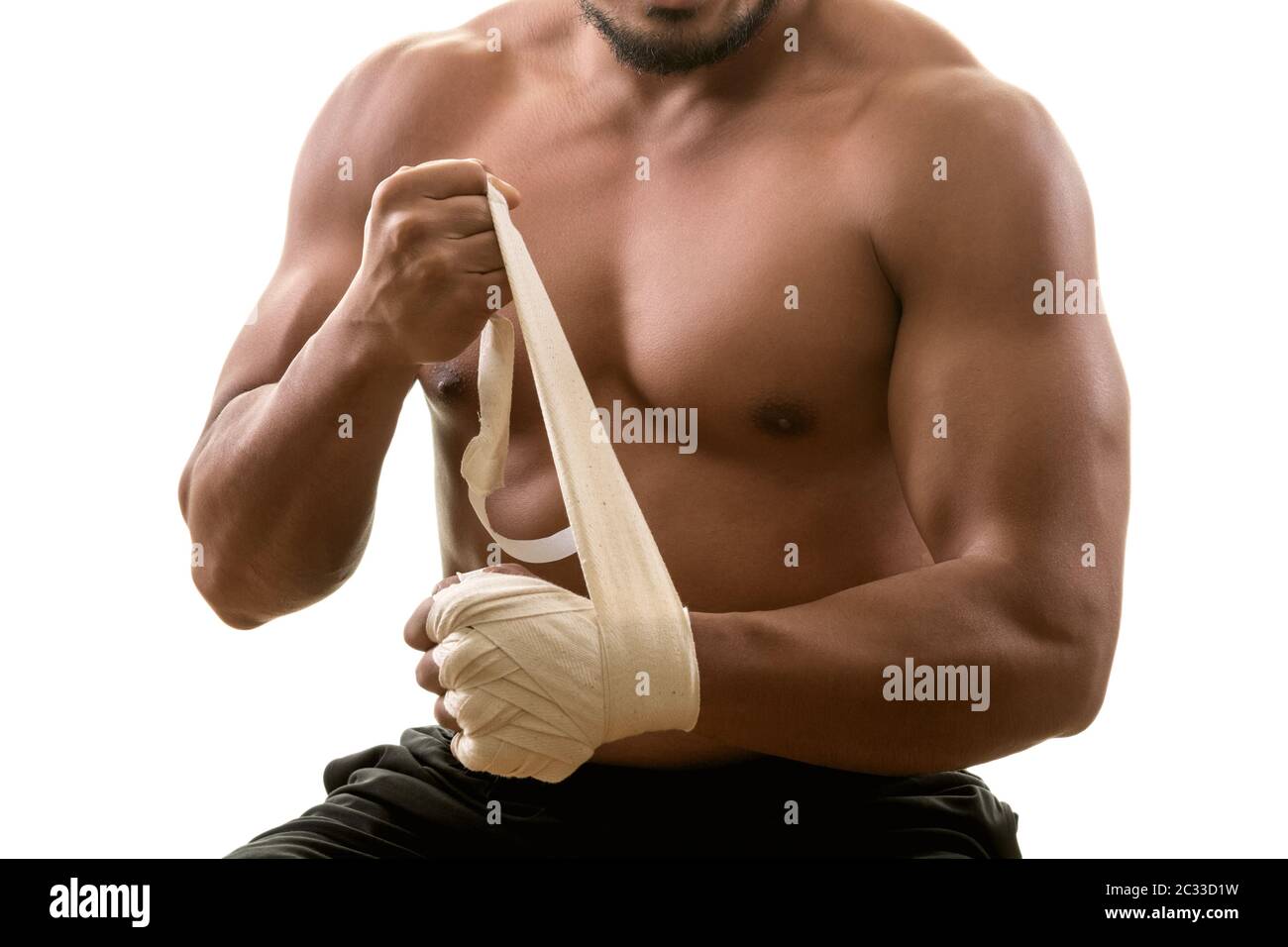 Jeune homme musclé fort mettant sur des bandages, isolé sur fond blanc. Arts martiaux, fitness, concept d'entraînement Banque D'Images