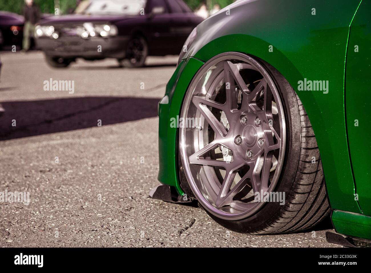 Roues forgées à réglage exclusif montées sur une voiture personnalisée,  tirées dans un film de vinyle vert. Voiture basse avec suspension  pneumatique Photo Stock - Alamy