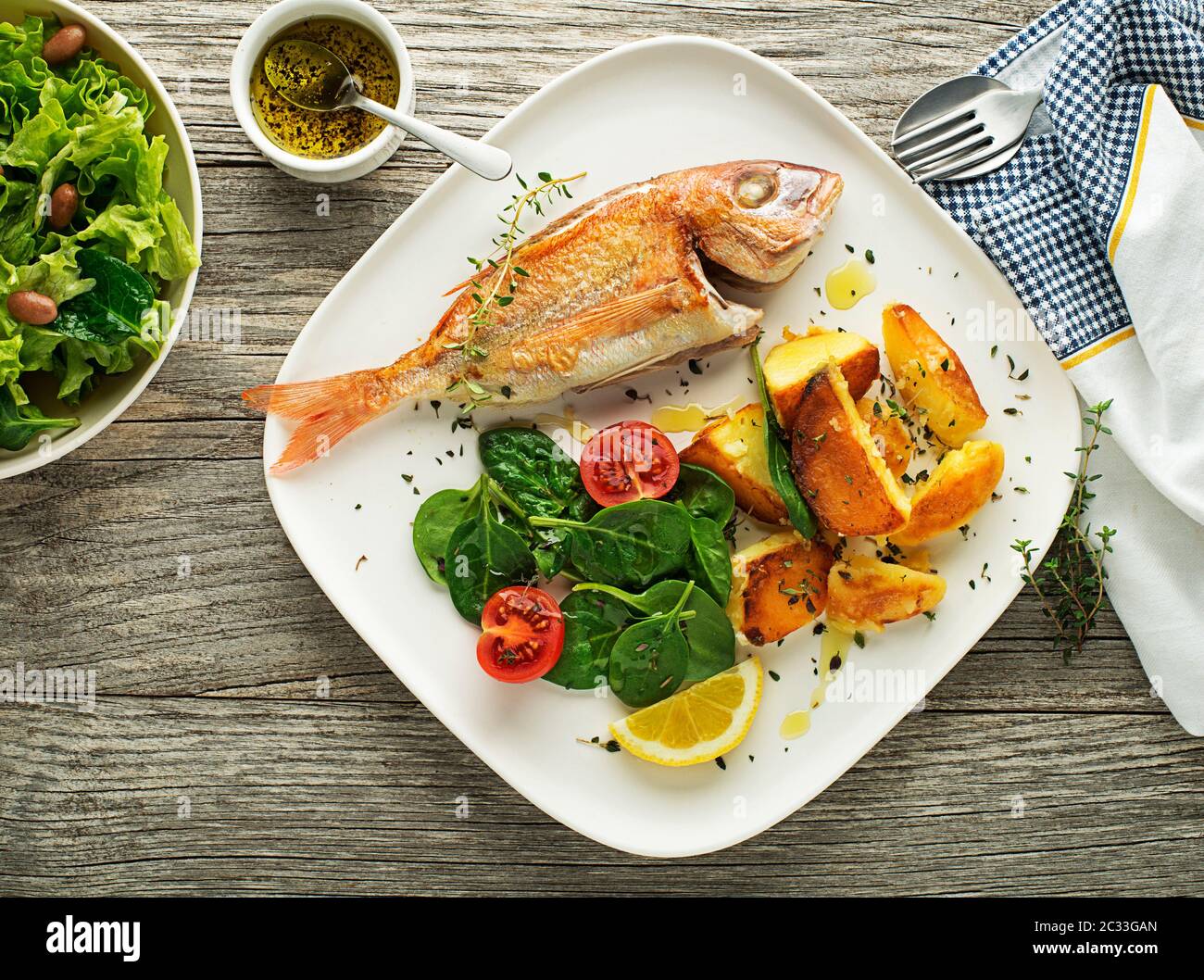 Délicieuse viande de poisson grillée avec épinards et pommes de terre sur fond vintage. Repas de régime sain Banque D'Images