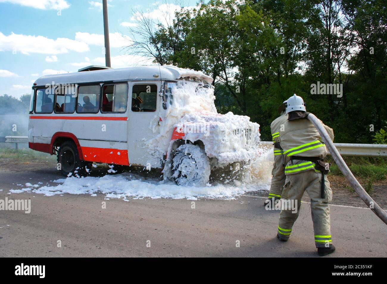 Les pompiers éteignent un incendie dans un bus en feu Banque D'Images