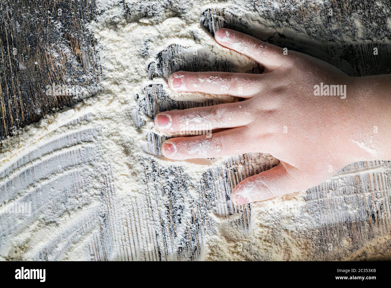 traces de la main de l'enfant sur une grande quantité de farine après avoir fait cuire de véritables pâtes de blé, empreintes digitales et palmiers Banque D'Images