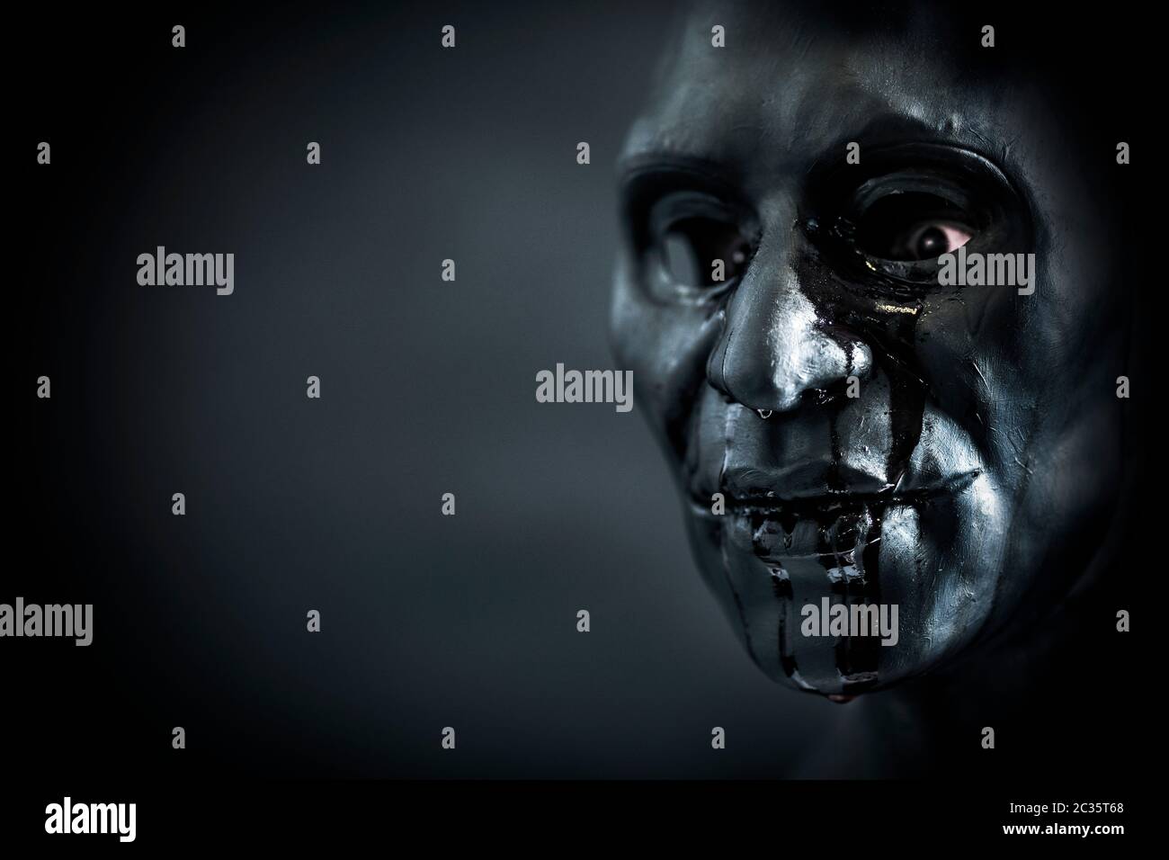 La figure effrayante creepy avec masque sanglant dans le noir Banque D'Images