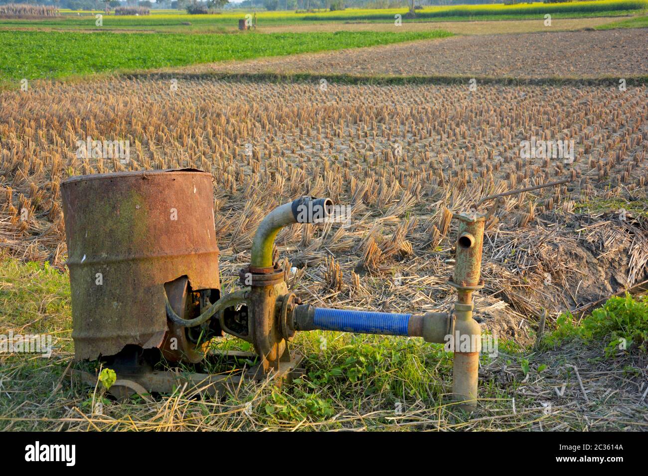 Ancienne pompe à eau rouillée utilisée par les agriculteurs indiens pour cultiver du paddy dans un champ à pipeline profond et peu profond, avec une focalisation sélective Banque D'Images