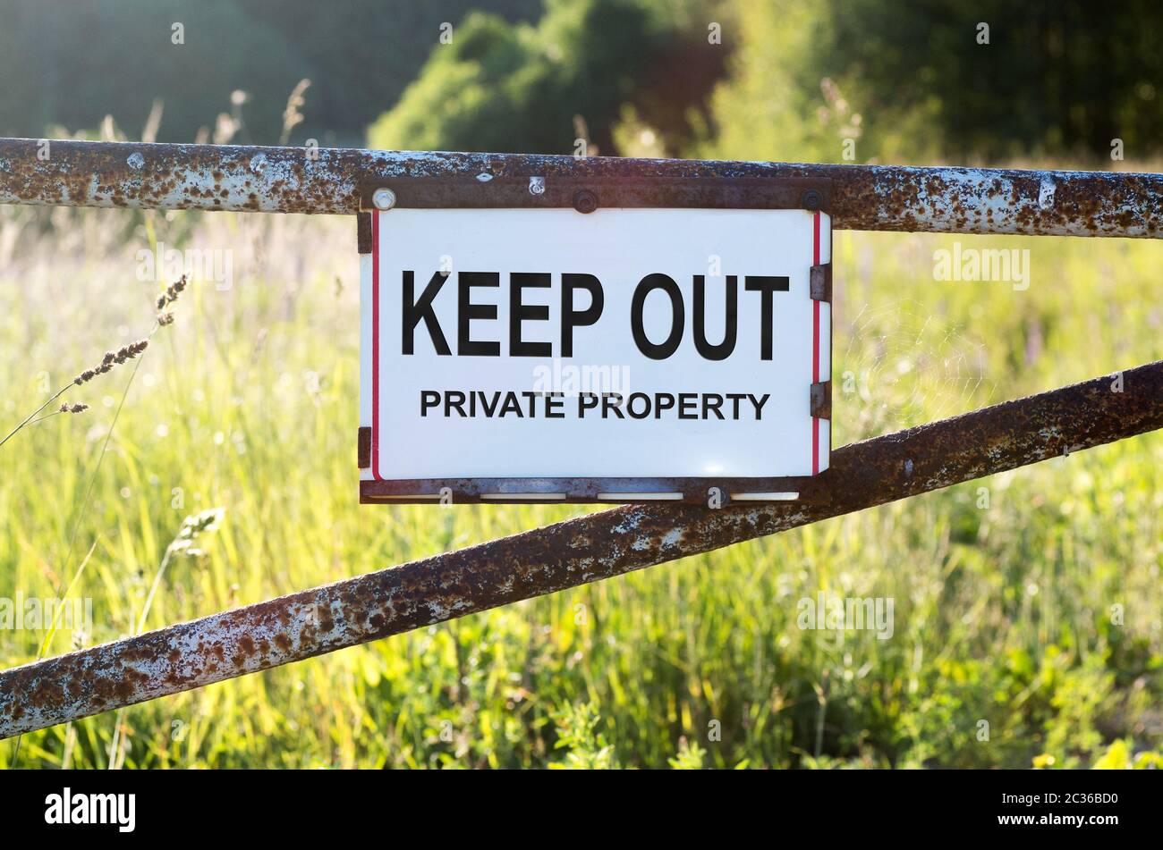 Signer la propriété privée et garder sur une barrière métallique sur le chemin de terre Banque D'Images