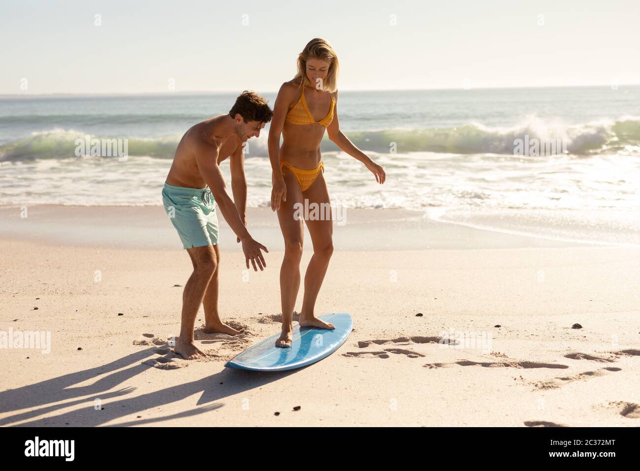 Jeunes caucasiens pratiquant le surf sur la plage Banque D'Images