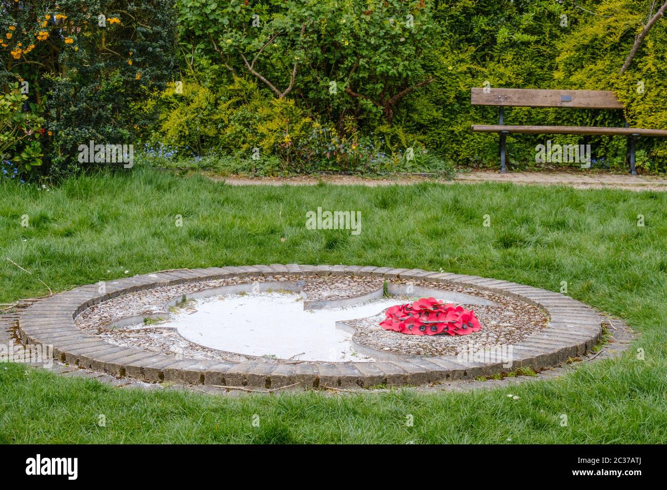 Gros plan de la colombe de la paix sculptée dans le sol avec une couronne du jour du souvenir à côté. Pinner Memorial Park, Pinner, NW London Banque D'Images