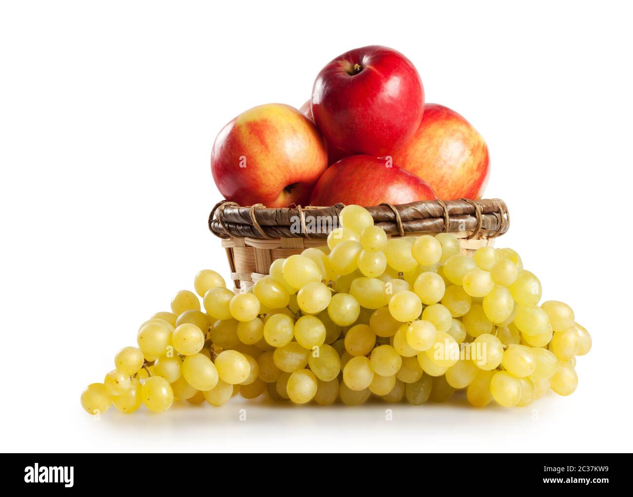 Raisins et pommes dans un panier isolé sur fond blanc Banque D'Images