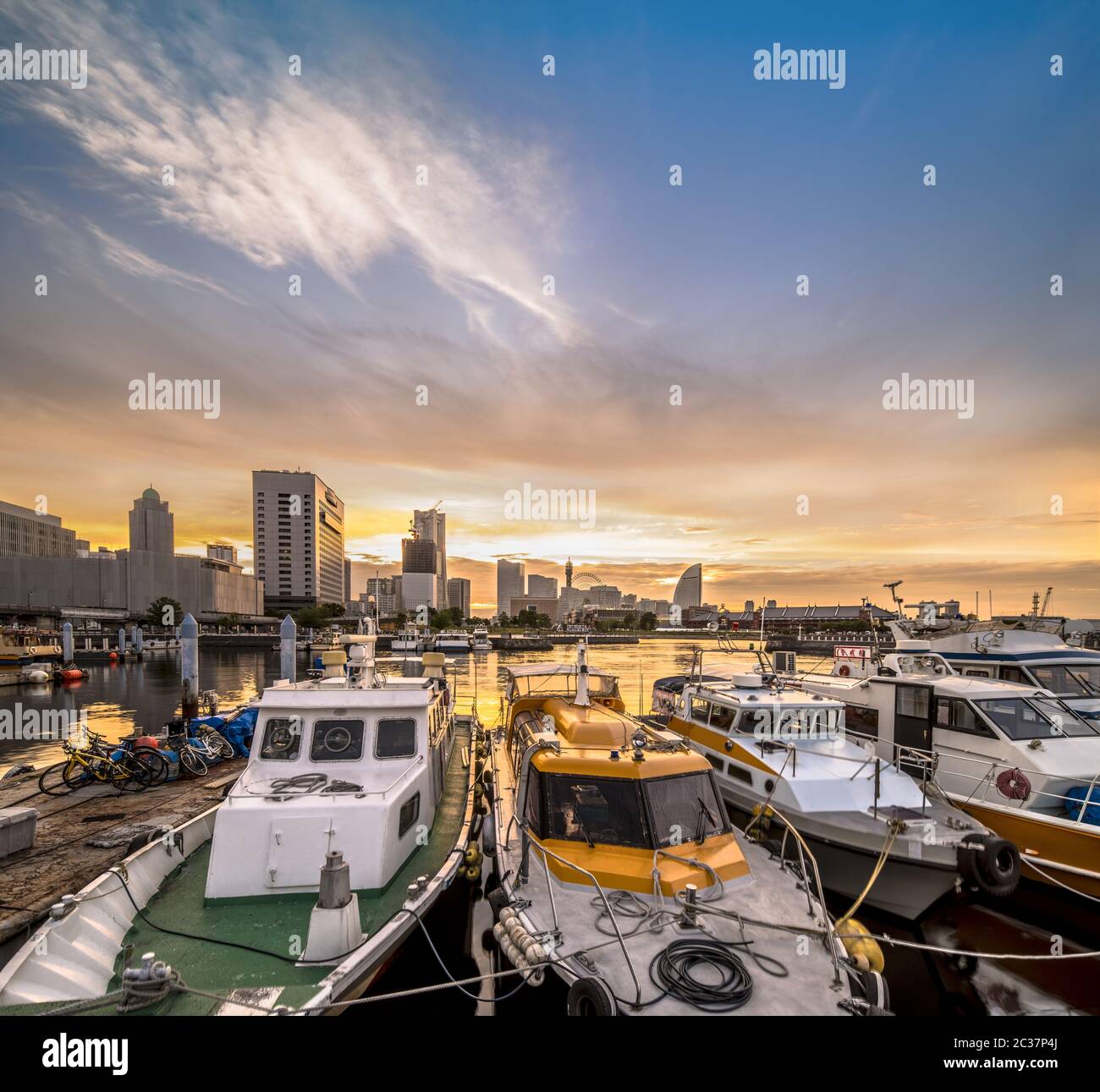 Panorama depuis le port de l'embarcadère d'Osanbashi à Yokohama où des bateaux de pêche colorés sont amarrés au coucher du soleil Banque D'Images