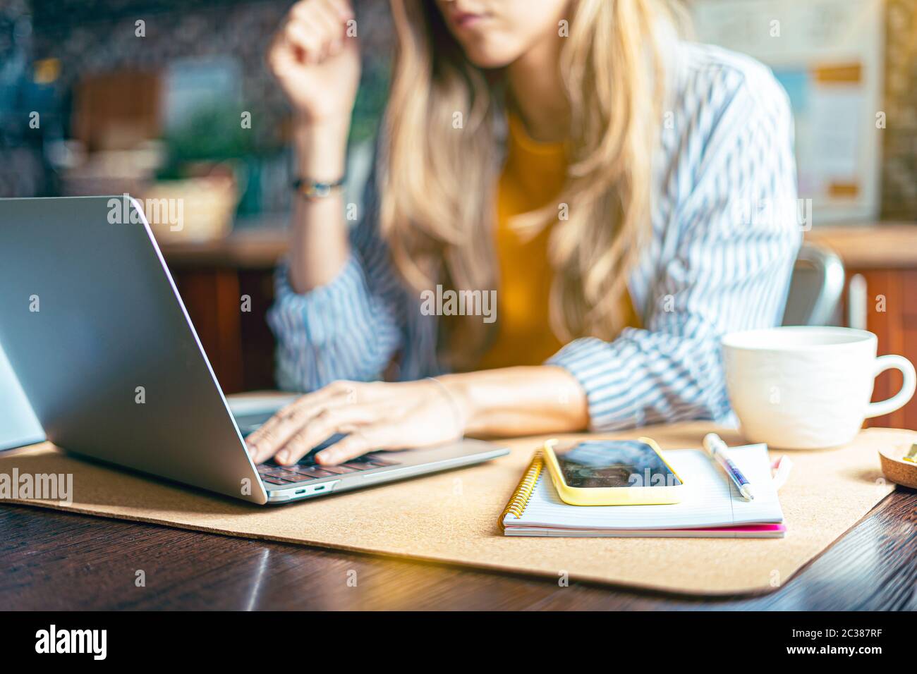 La femme de bureau à domicile et l'éducation en ligne à distance. Petite fille de belle femme travaillant à bloc-notes dans la cuisine et de boire du café à la maison Banque D'Images