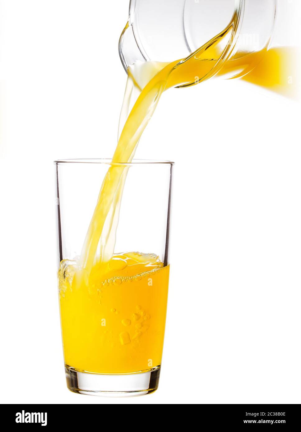 Le jus d'Orange versé dans un verre d'une carafe isolé sur fond blanc Banque D'Images