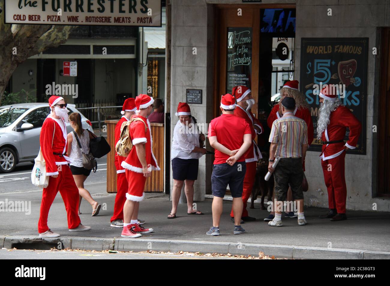Les personnes habillées comme le Père Noël quittent le pub The Forresters au 336 Riley St, Surry Hills pour se rendre au pub suivant sur la route SantaCon. Banque D'Images