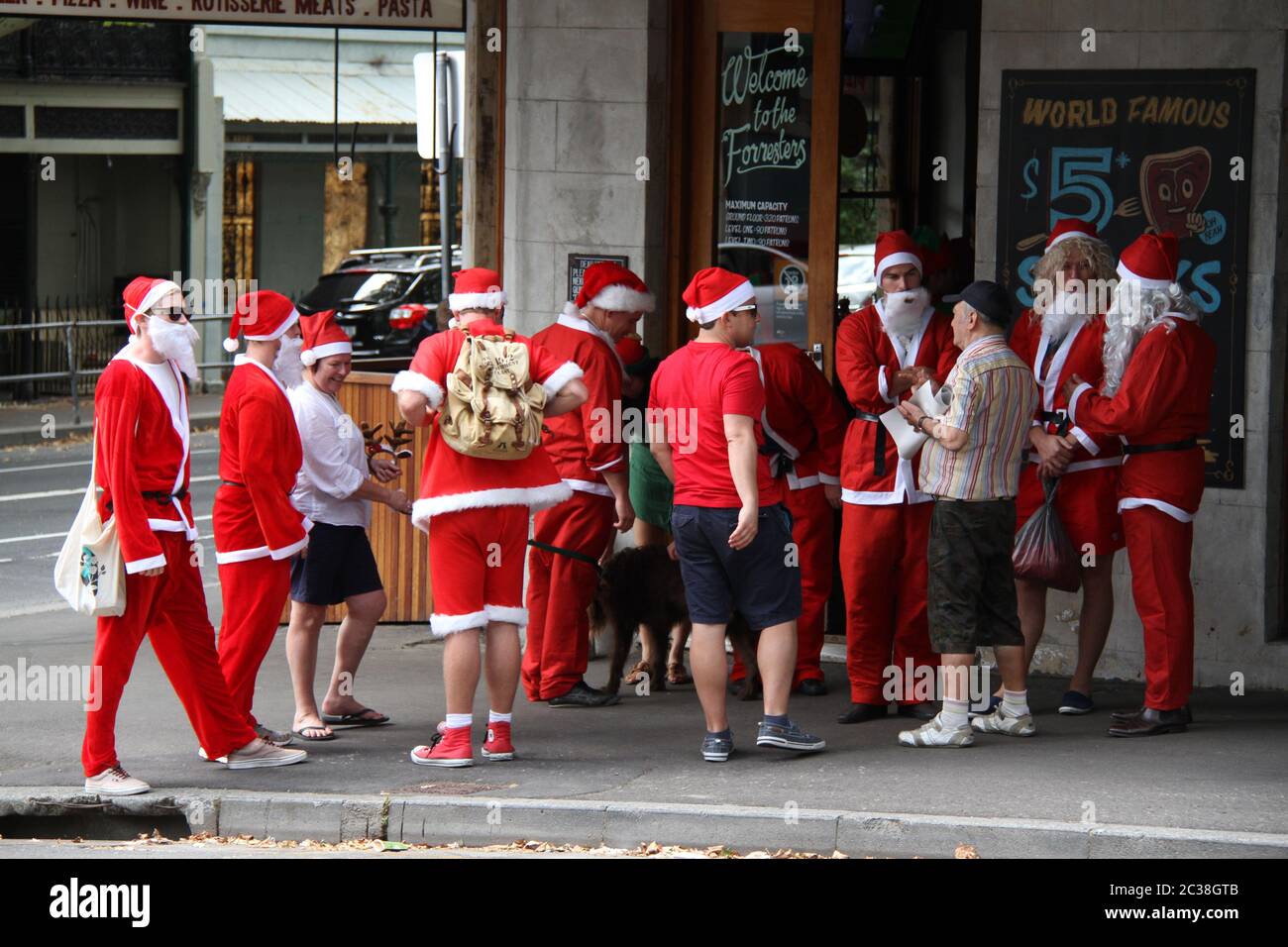 Les personnes habillées comme le Père Noël quittent le pub The Forresters au 336 Riley St, Surry Hills pour se rendre au pub suivant sur la route SantaCon. Banque D'Images