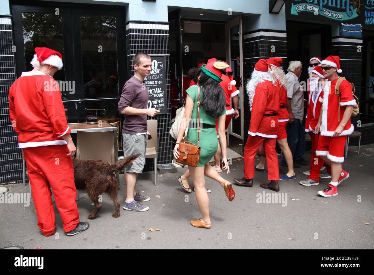 Les personnes qui prennent part au SantaCon habillé comme le Père Noël arrivent au pub Dolphin au 412 Crown Street, Surry Hills. Banque D'Images