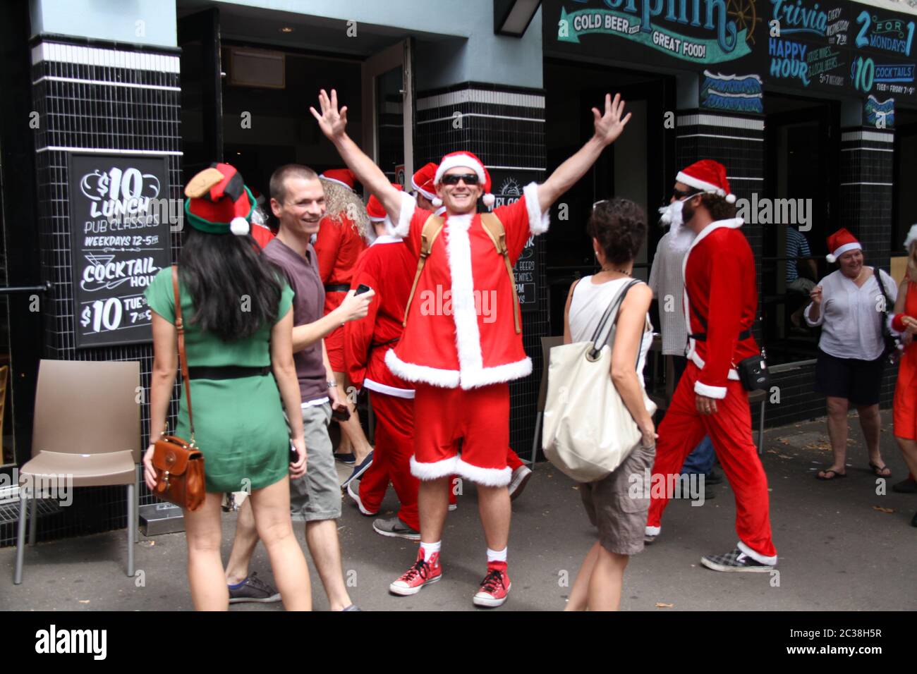 Les personnes qui prennent part au SantaCon habillé comme le Père Noël arrivent au pub Dolphin au 412 Crown Street, Surry Hills. Banque D'Images