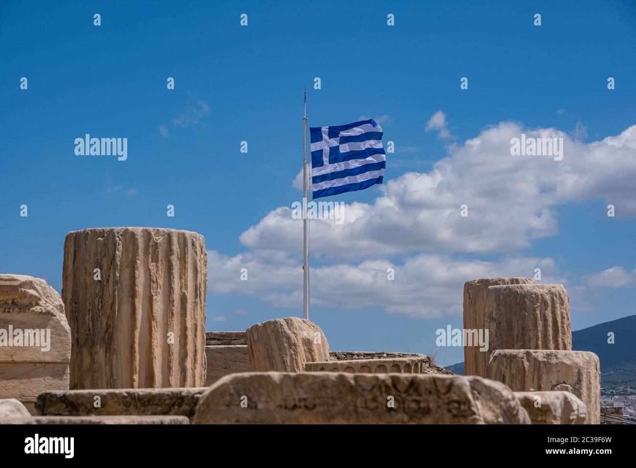 Acropole d'Athènes, Grèce. Drapeau grec agitant sur le poteau, ancienne colonne reste sur fond bleu ciel, printemps jour ensoleillé. Banque D'Images