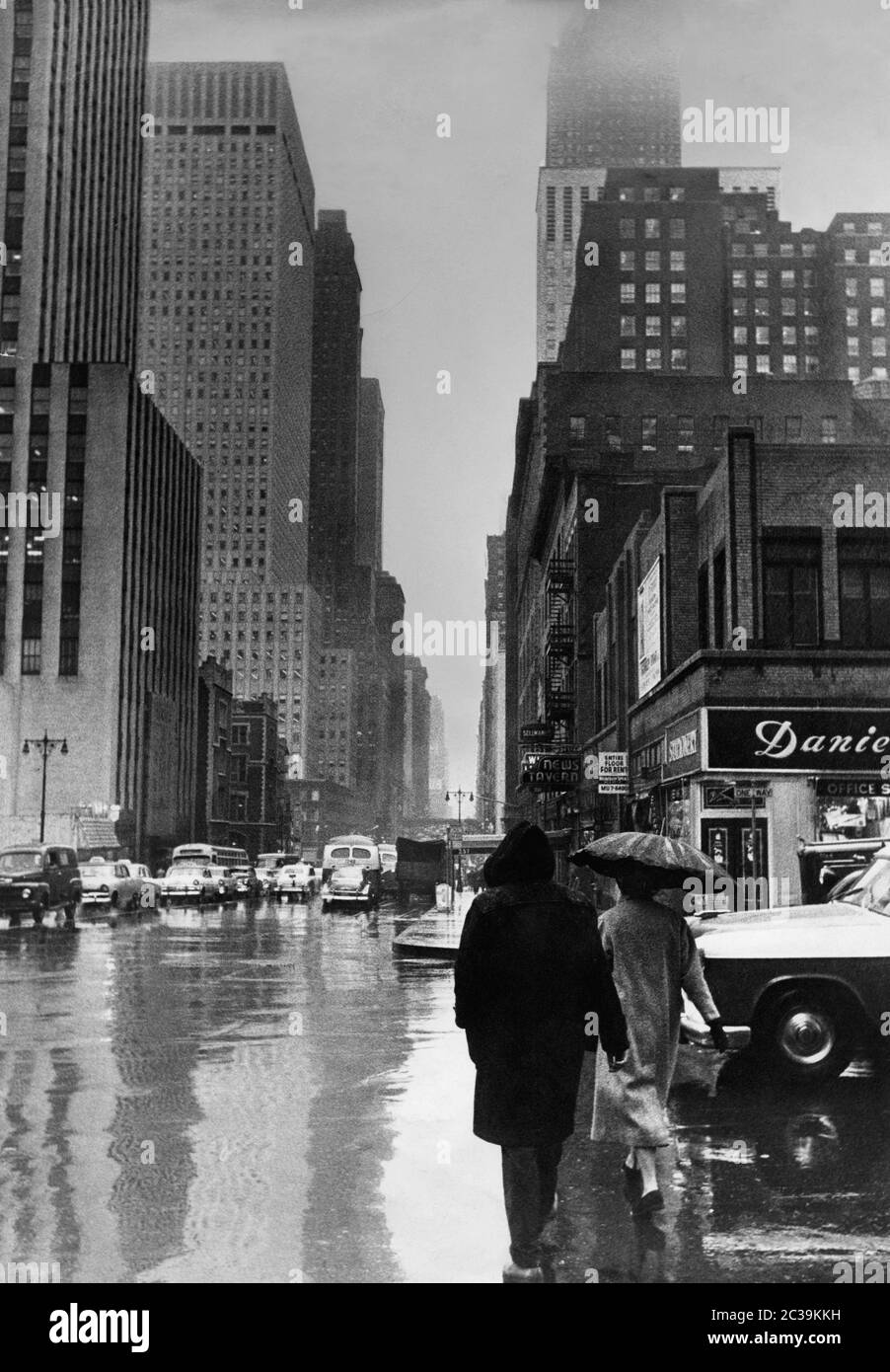 Entre les gratte-ciels de New York sur East 42nd Street (intersection 2nd Avenue) par temps pluvieux dans les années 1980. Dans l'arrière-plan à droite, se trouve le Chrysler Building. Sur la gauche en face se trouve le Daily News Building. Banque D'Images