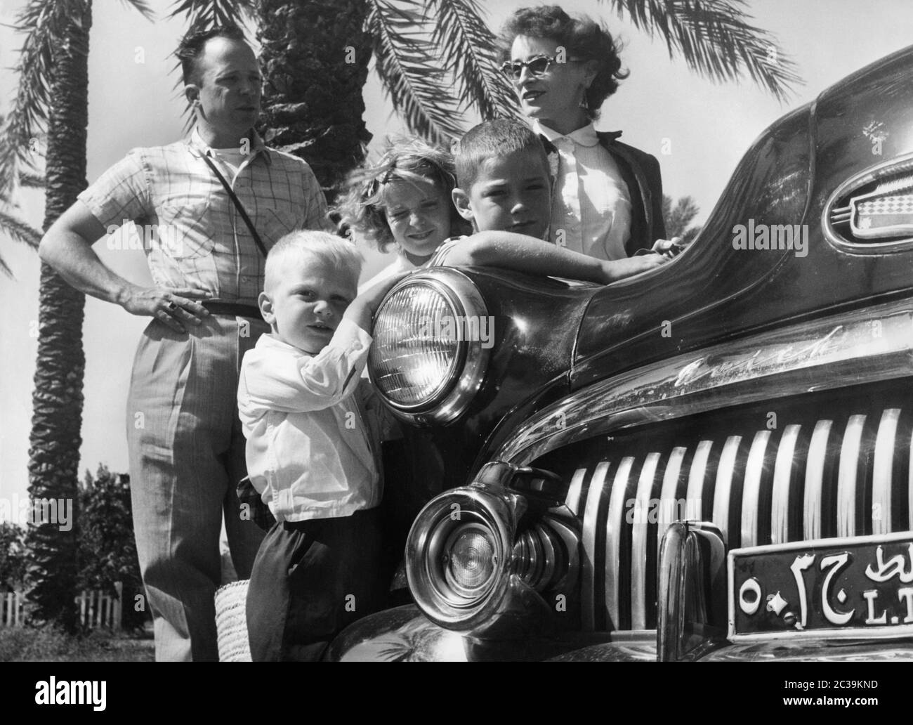 Une famille américaine avec une voiture de fonction Buick à partir du début des années 1950, lors d'un séjour à l'étranger dans un pays arabe dans les années 1950. Banque D'Images