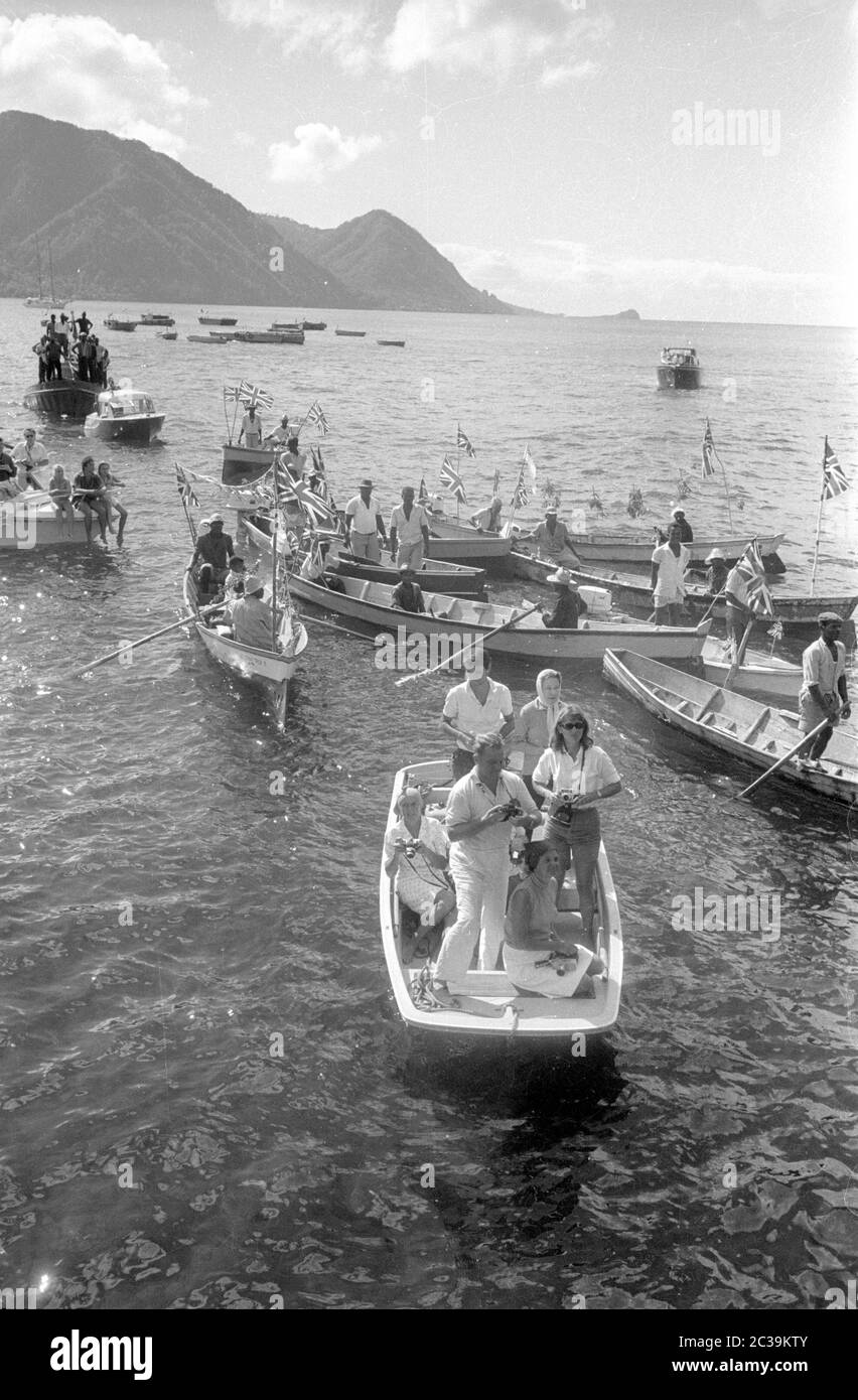 Lors d'une visite de la reine britannique Elizabeth II à la colonie britannique d'Antigua dans les Caraïbes, un certain nombre de Britanniques, de touristes ou de journalistes sont en face du port, dans des bateaux décorés avec l'Union Jack. Banque D'Images