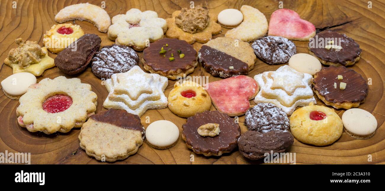 Mélange coloré de biscuits de Noël fait maison sur une planche en bois foncé Banque D'Images