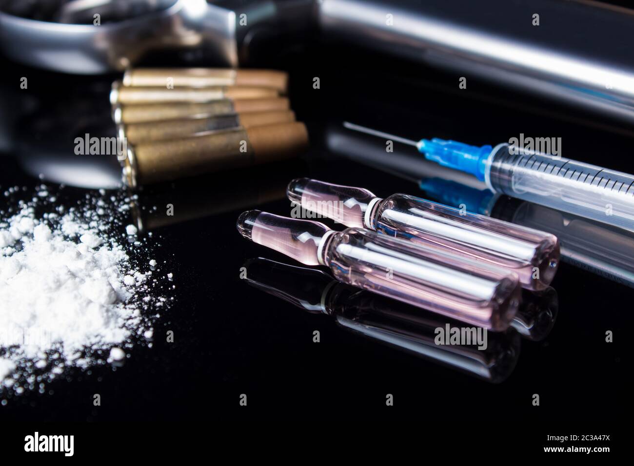Un pistolet à balles, seringue et les médicaments se trouvent sur le tableau noir. Mauvaises habitudes dangereuses, la dépendance aux drogues et du jeu. Crime à cause de la drogue. La vente, Banque D'Images