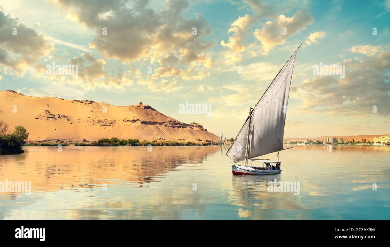 Nuages au-dessus du Nil et voilier à Assouan au coucher du soleil Banque D'Images