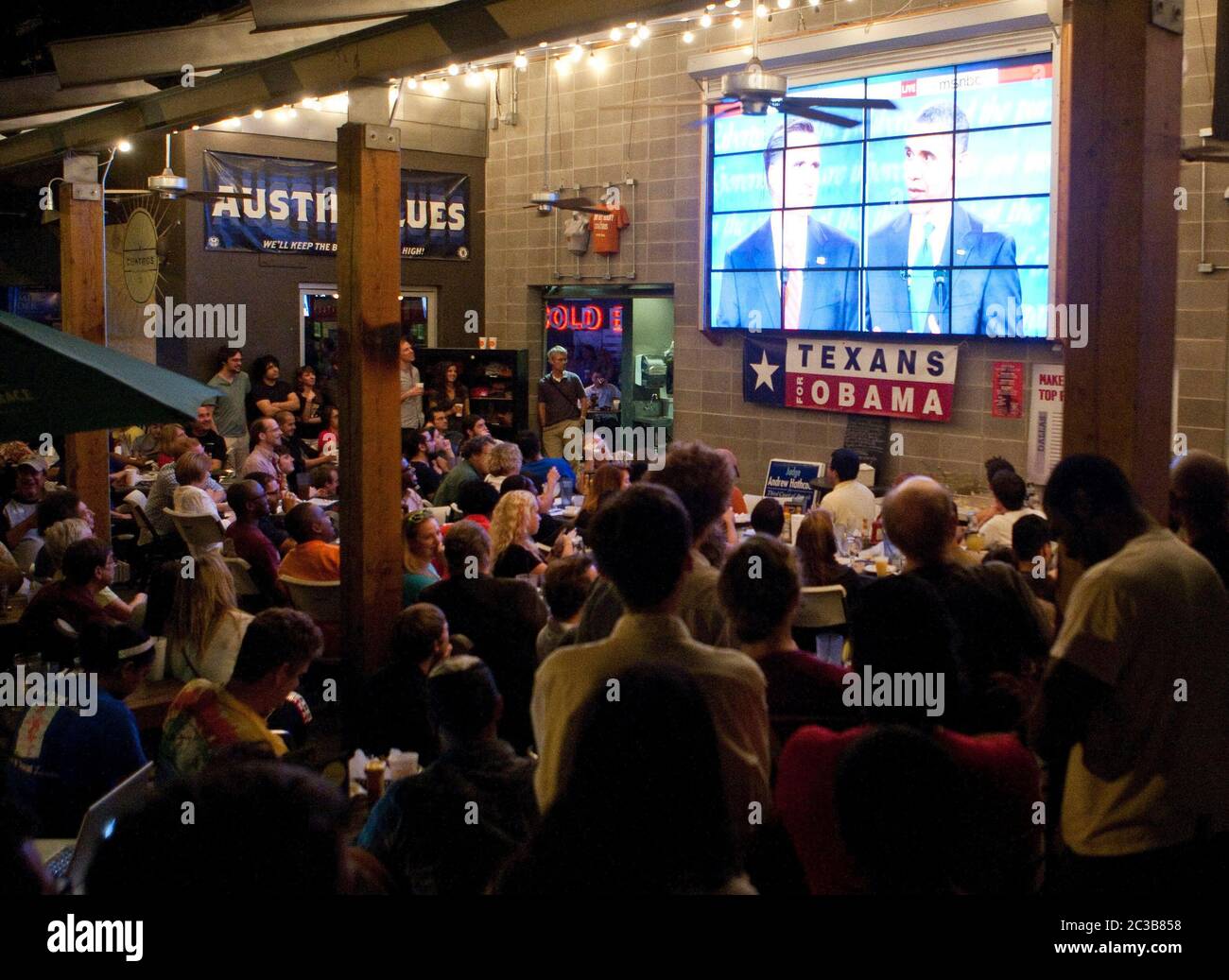 Austin, Texas Etats-Unis, 3 octobre 2012: Un grand groupe assiste à une soirée de montre pour le premier débat présidentiel Mitt Romney/Barack Obama à la télévision dans un restaurant proche du campus de l'Université de Tée. ©MKC / Daemmrich photos Banque D'Images