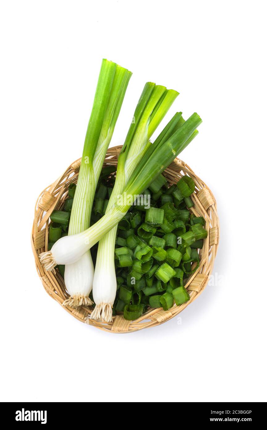 Les oignons verts frais mûrs (échalotes ou oignons verts) avec oignons hachés dans panier sur fond blanc Banque D'Images