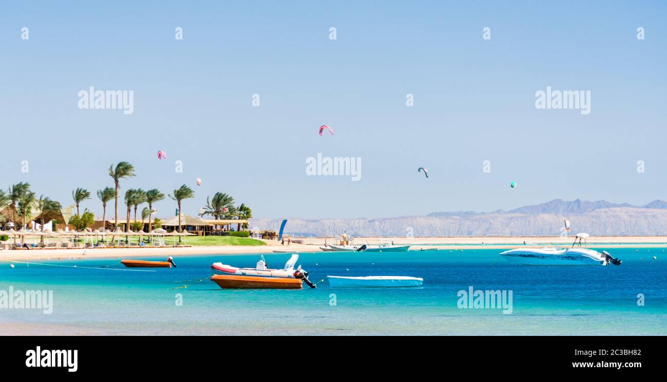 Hôtel avec palmiers sur la mer Rouge en Egypte Dahab avec des bateaux et des cerfs-volants Banque D'Images