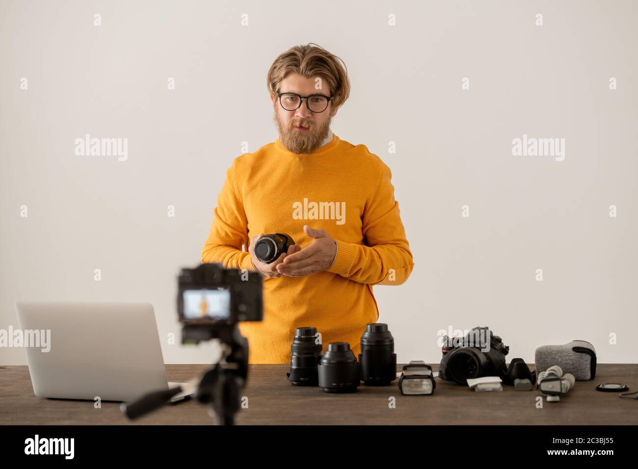 Photographe barbu montrant des éléments de la nouvelle maquette professionnelle à son public en ligne à la leçon Banque D'Images