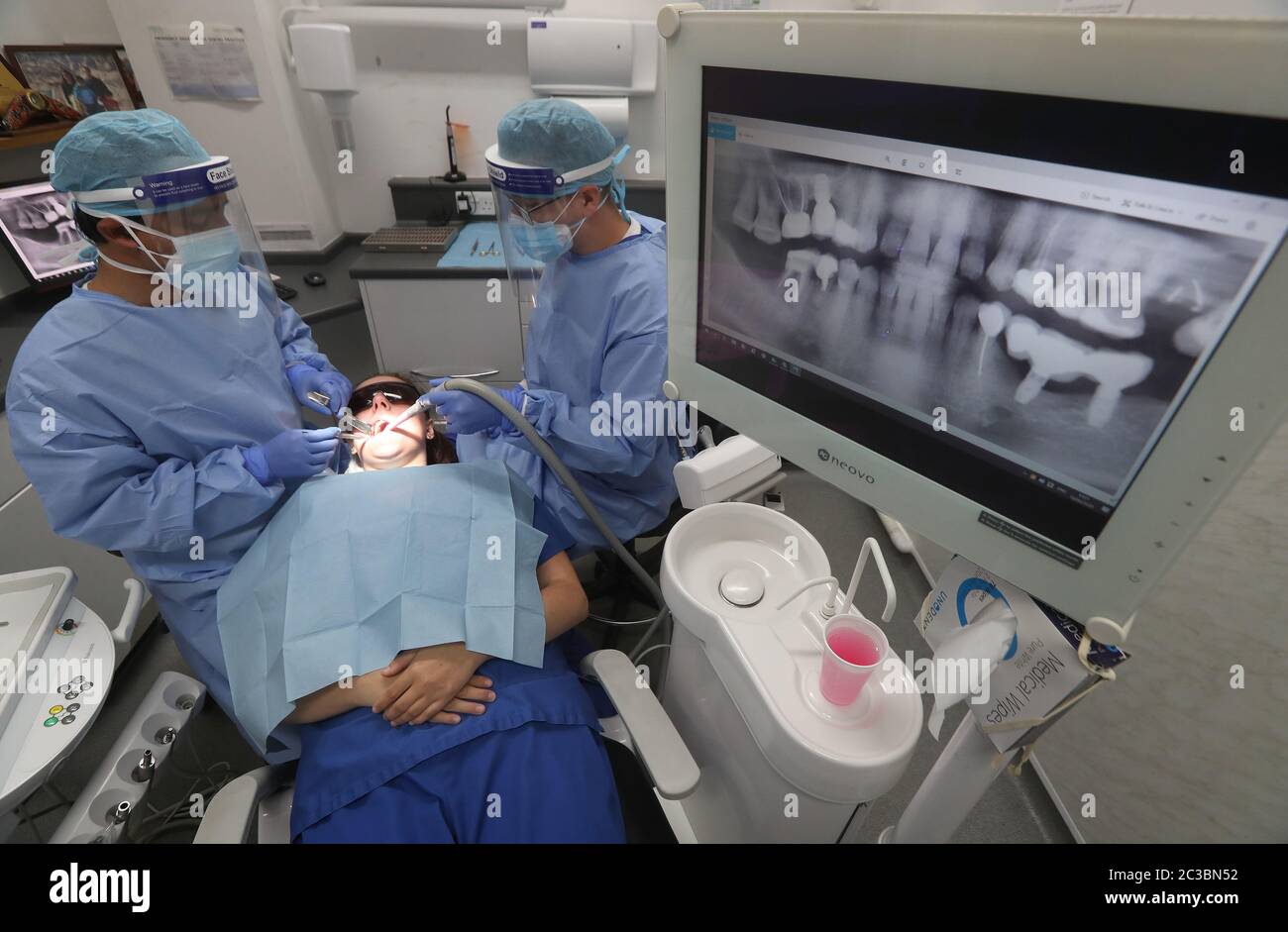 Le chirurgien dentaire et spécialiste, Girish Bharadwaj(L), en compagnie de l'infirmière Mark Scott, démontre la pratique professionnelle de la chirurgie dentaire et orale d'Achilview à Armadale, après l'annonce que l'Écosse passera à la deuxième phase de son plan en quatre étapes pour se détendre. Banque D'Images
